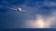 Plane flying lightning ocean