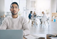 man sitting at computer looking suspicious