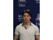 Jakhongir in white collared shirt in front of Eller photo backdrop