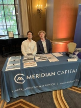 two boys in suits sitting at a table